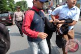 Polisi berpakaian sipil mengamankan seorang pengunjuk rasa dari aliansi buruh, ketika menggelar aksi memperingati Hari Buruh Internasional, di depan Gelanggang Remaja Medan, Sumatera Utara, Minggu (1/5). Polisi mengamankan puluhan pengunjuk rasa dari salah satu aliansi buruh karena dianggap memprovokasi ketika elemen buruh lainnya melakukan aksi didalam gedung Gelanggang Remaja. ANTARA SUMUT/Irsan Mulyadi/16