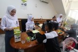 Sejumlah petugas Bank Bukopin mengenakan seragam sekolah saat melayani nasabah di Medan, Sumatera Utara, Senin (2/5). Menggunakan seragam sekolah yang dikenakan petugas bank tersebut, dalam rangka memperingati Hari Pendidikan Nasional yang diperingati setiap 2 Mei. ANTARA SUMUT/Septianda Perdana/16