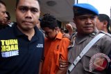 Petugas kepolisian mengawal seorang tersangka kasus pembunuhan Roy Mando Sah Siregar (20) saat gelar kasus di Mapolresta Medan, Sumatera Utara, Selasa (3/5). Tersangka yang merupakan mahasiswa di Fakultas FKIP Universitas Muhammadiyah Sumatera Utara (UMSU) itu tega membunuh dosennya lantaran sakit hati karena sering dimarahi namun akibat perbuatannya tersangka dijerat hukuman penjara 15 tahun dan diancam hukuman mati. ANTARA SUMUT/Septianda Perdana/16