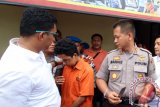 Kapolresta Medan Kombes Pol Mardiaz Kusin Dwihananto (kanan) memperlihatkan barang bukti pisau yang digunakan Roy Mando Sah Siregar (20) saat gelar kasus di Mapolresta Medan, Sumatera Utara, Selasa (3/5). Tersangka yang merupakan mahasiswa di Fakultas FKIP Universitas Muhammadiyah Sumatera Utara (UMSU) itu tega membunuh dosennya lantaran sakit hati karena sering dimarahi namun akibat perbuatannya tersangka dijerat hukuman penjara 15 tahun dan diancam hukuman mati. ANTARA FOTO/Septianda Perdana/16