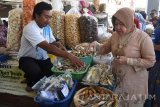 Walikota Surabaya, Tri Rismaharini (kanan) membeli ikan asap di Sentra Ikan Bulak (SIB) Surabaya, Jawa Timur, Rabu (4/5). SIB yang mampu menampung sekitar 240 lapak tersebut diharapkan mampu mengubah perekonomian nelayan di kawasan tersebut menjadi lebih baik. Antara Jatim/M Risyal Hidayat/zk/16