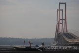 Sejumlah warga menikmati suasana sore hari di sekitar Jembatan Suramadu, Surabaya, Jawa Timur, Jumat (6/5). Jembatan dengan panjang sekitar 5,4 kilometer tersebut menjadi salah satu tempat wisata yang banyak dikunjungi warga untuk mengisi hari libur. Antara Jatim/Moch Asim/zk/16