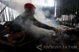 Warga melakukan pengasapan ikan Pari di kampung nelayan Tambak Wedi, Surabaya, Jawa Timur, Jumat (6/5). Menurut warga produksi ikan asapan di daerah tersebut mengalami peningkatan karena tingginya permintaan, dari rata-rata 50 kilogram per hari menjadi 80-100 kilogram per hari untuk kemudian dijual dengan harga Rp50.000 per kilogram. Antara Jatim/Moch Asim/zk/16