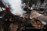 Warga melakukan pengasapan ikan Pari di kampung nelayan Tambak Wedi, Surabaya, Jawa Timur, Jumat (6/5). Menurut warga produksi ikan asapan di daerah tersebut mengalami peningkatan karena tingginya permintaan, dari rata-rata 50 kilogram per hari menjadi 80-100 kilogram per hari untuk kemudian dijual dengan harga Rp50.000 per kilogram. Antara Jatim/Moch Asim/zk/16