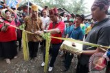 Gubernur Kalsel Sahbirin Noor memotong tali daun kelapa di dampingi Damang Khairul Sadikin saat akan memasuki kampung adat Loksado, Sabtu (7/5). Desa Loksado menggelar Festival Loksado 2016 untuk sebagai sarana promosi wisata dan melestarikan budaya. Foto Antaranews Kalsel/Herry Murdy Hermawan