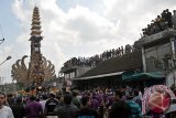 Ratusan warga menggotong Bade atau menara bertingkat sembilan yang berisi jenazah anggota keluarga Kerajaan / Puri Ubud, Cokorda Putra Widura dalam arak-arakan upacara Ngaben di Ubud, Bali, Minggu (8/5). Kremasi jenazah berskala besar tersebut disaksikan ribuan warga dan wisatawan sekaligus untuk memberi penghormatan terakhir. ANTARA FOTO/Nyoman Budhiana/i018/2016.