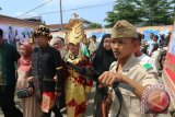 Pengantin pria Dedi Prasetio bersama istrinya Indah Purnama Sari Nasution dikawal pemuda berpakaian ala pejuang pada prosesi pesta pernikahan, di Medan, Sumatra Utara, Minggu (8/5). Konsep pesta pernikahan tersebut merupakan permintaan dari pihak keluarga pengantin untuk menghargai jasa para pejuang. ANTARA SUMUT/Irsan Mulyadi/16