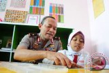 Kapolda Kalbar, Brigjen (Pol) Arief Sulistyanto (kiri) mendampingi pelajar membaca buku saat peresmian Taman Bacaan 'Kemala Cinta Indonesia' di Kampung Beting, Pontianak, Kalbar, Senin (9/5). Taman bacaan yang diperuntukkan bagi anak-anak yang bermukim di kawasan tersebut, bertujuan untuk menumbuhkan minat membaca dan belajar serta menghapus stigma negatif yang selama ini disandang Kampung Beting Permai sebagai tempat peredaran narkoba. ANTARA FOTO/Jessica Helena Wuysang/16