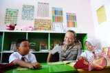 Kapolda Kalbar, Brigjen (Pol) Arief Sulistyanto (tengah) berbicara dengan dua pelajar usai peresmian Taman Bacaan 'Kemala Cinta Indonesia' di Kampung Beting, Pontianak, Kalbar, Senin (9/5). Taman bacaan yang diperuntukkan bagi anak-anak yang bermukim di kawasan tersebut, bertujuan untuk menumbuhkan minat membaca dan belajar serta menghapus stigma negatif yang selama ini disandang Kampung Beting Permai sebagai tempat peredaran narkoba. ANTARA FOTO/Jessica Helena Wuysang/16