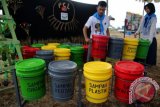 Aktivis yang tergabung dalam komunitas Pelajar Cinta Lingkungan (PCL) mengatur tong sampah hasil daur ulang dari kaleng cat di Banda Aceh, Aceh, Minggu (8/5). Tong sampah hasil kreasi pelajar dari beberapa Sekolah Menengah Atas yang dipamerkan di Festival Kota Kita untuk meningkatkan kesadaran membuang sampah pada tempatnya itu dijual Rp600.000 hingga Rp800.000 per unit. ANTARA FOTO/Irwansyah Putra/kye/16.
