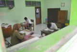 Siswa SMP Luar Biasa mengikuti Ujian Nasional (UN) di SMP Luar Biasa (SMPLB) Dharma Wanita, Kota Madiun, Jawa Timur, Senin (9/5). Pelaksanaan UN tingkat SMP di sekolah tersebut diikuti dua orang siswa tuna rungu wicara. Antara Jatim/Foto/Siswowidodo/zk/16