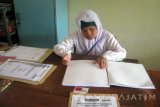 Seorang peserta tuna netra mengerjakan ujian nasional berhuruf braile dengan mata pelajaran Bahasa Indonesia di Sekolah Menengah Pertama (SMPLB) Bintoro, Kecamatan Patrang, Kabupaten Jember, Jawa Timur, Senin (9/5). UN tingkat SMP dan sederajat digelar serentak sejak Senin hingga Kamis (12/5). Antarajatim/ Zumrotun Solichah/zk/16