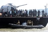 Sembilan orang perompak dijaga ketat oleh anggota TNI AL lengkap dengan senjata laras panjang di buritan KRI Untung Suropati (USP)-372 ketika akan bersandar di Dermaga Ujung Koarmatim Surabaya, Jawa Timur, Selasa (10/5). Jajaran Koarmatim berhasil mengamankan sembilan orang perompak yang melakukan pembajakan Motor Vessel (MV) Hai Soon 12 berbendera Singapura yang bermuatan 200 Kilo Liter Minyak. Antara Jatim/M Risyal Hidayat/zk/16