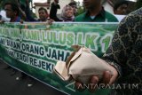 Sejumlah mahasiswa yang tergabung dalam Himpunan Mahasiswa Islam (HMI) membagikan nasi bungkus kepada pengguna jalan saat aksi simpatik di depan Mapolresta Kediri, Jawa Timur, Rabu (11/5). Aksi membagikan 250 nasi bungkus tersebut sebagai wujut protes peryataan Wakil Ketua Komisi Pemberantasan Korupsi (KPK) Saut Situmoran yang dinilai mencemarkan nama baik HMI. Antara Jatim/Prasetia Fauzani/zk/16