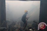 Petugas pemadam kebakaran berusaha memadamkan api yang menghanguskan kios, di Jalan Gatot Subroto, Medan, Sumatera Utara, Kamis (12/5). Sedikitnya lima kios terbakar pada peristiwa tersebut, diduga akibat hubungan arus pendek listrik. ANTARA SUMUT/Irsan Mulyadi/16