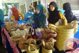 Tanjung, 13/5 - Salah satu anggota tim penggerak PKK Kecamatan Banua Lawas memamerkan gula merah lokal produksi masyarakat termasuk aneka kerajinan tangan seperti anyaman tas. Sejumlah produk makanan ringan juga disajijan pada pameran yang digelar di Desa Hapalah Kecamatan Banua Lawas.Foto:Antara/Herlina Lasmianti