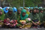 Warga Nahdliyin berdoa bersama saat Haul Syuhada Madiun dan Ikrar Setia Negara Kesatuan Republik Indonesia (NKRI) di areal Monumen Keganasan Partai Komunis Indonesia (PKI) Kresek, Kabupaten Madiun, Jawa Timur, Kamis (12/5).  Haul tersebut selain untuk mendoakan para syuhada yang menjadi korban keganasan PKI juga untuk antisipasi bangkitnya lagi PKI. Antara Jatim/Foto/Siswowidodo/zk/16 