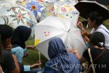 Sejumlah warga melukis dengan menggunakan media payung secara bersama-sama saat acara 'Festival Aloon-Aloon' di Alun-alun Kota Kediri, Jawa Timur, Sabtu (14/5). Festival yang menyajikan berbagai kegiatan seni tersebut bertujuan menghidupkan kembali ruang publik Alun-alun sebagai tempat interaksi sosial segala lapisan masyarakat. Antara Jatim/Prasetia Fauzani/zk/16