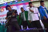 Charly Van Houten Setia Band (kiri) bersama Wakil Gubernur Jatim Saifullah Yusuf (dua kanan) menyanyikan lagu saat Harlah ke-66 Fatayat NU dan ke-82 GP Ansor di GOR Jombang, Jawa Timur, Minggu (15/5). Charly Setia Band dalam kesempatan tersebut menyanyikan sejumlah lagu hits seperti, Isabella, Memujamu, Asmara, untuk menghibur anggota Fatayat NU dan GP Ansor Jombang. Antara Jatim/Syaiful Arif/zk/16