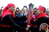 Bupati Maluku Tengah Abua Tuasikal (kiri) menyerahkan obor perjuangan Pahlawan Nasional Thomas Matulessy atau Kapitan Pattimura kepada Gubernur Maluku Said Assagaff (kanan) saat peringatan Hari Perjuangan Pattimura ke-199 yang berlangsung di pelataran Benteng Duurstede, Pulau Saparua, Maluku Tengah, Provinsi Maluku, Minggu (15/5). Arak-arakan obor Pattimura dari Gunung Saniri ke pelataran Benteng Duurstede merupakan sebuah tradisi yang menggambarkan perjuangan Pattimura. ANTARA FOTO/Izaac Mulyawan/nz/16.