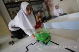 Tim robotika SMP Al Azhar 13 (kiri-kanan) Inggita Nirmala, Abiyyuda Naufal, Anindita Pramesthi mendemonstrasikan robot kategori Rescue Line di SMP Al Azhar 13 Surabaya, Jawa Timur, Kamis (19/5). Tim robotika SMP Al Azhar yang telah meraih peringkat pertama dalam Robocup Singapura Open 2016 pada awal April lalu tersebut akan maju ke tingkat Leipzig di Jerman pada Juni mendatang. Antara Jatim/Moch Asim/zk/16