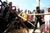 Pangdam XII Tanjungpura, Mayjen TNI Agung Risdhianto (dua kanan) berhasil menebas batang kayu lintang saat menjalani rangkaian upacara adat Dayak Taman pada Pekan Gawai Dayak ke-31 di Rumah Radakng, Pontianak, Kalbar, Sabtu (21/5). Mayjen TNI Agung Risdhianto menjadi tamu kehormatan untuk menjalani rangkaian upacara Pasiap, Mamandung dan Mamasi yang digelar suku Dayak Taman dari Kabupaten Kapuas Hulu, Kalbar. ANTARA FOTO/Jessica Helena Wuysang/16