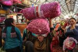 Buruh angkut sedang mengangkut karung berisi bawang merah di pasar Pabean Surabaya, Jawa Timur. (ANTARA FOTO/Didik Suhartono/Dok).