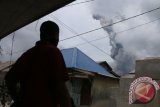 Seorang warga melihat Gunung Sinabung mengeluarkan material vulkanik ketika erupsi, di Desa Sukandebi, Karo, Sumatera Utara, Selasa (24/5). Aktivitas Gunung Sinabung yang berstatus Awas (Level) IV semakin meningkat, ditandai dengan erupsi dan luncuran awan panas yang terjadi menyebabkan sejumlah desa tertutup debu vulkanik. ANTARA SUMUT/Irsan Mulyadi/16