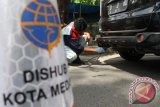 Petugas melakukan uji emisi gratis pada kendaraan roda empat yang melintas di Jalan Gatot Subroto Medan, Sumatera Utara, Rabu (25/5). Uji emisi tersebut bertujuan untuk memantau kadar emisi buang kendaraan dalam rangka evaluasi kualitas udara perkotaan. ANTARA SUMUT/Septianda Perdana/16
