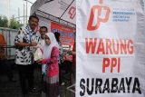 Kabid Perdagangan Dalam Negeri Disperindag Provinsi Jawa Timur Drajat Irawan (tengah) didampingi General Manager Perusahaan Perdagangan Indonesia (PPI) Cabang Regional Surabaya Sukri Hidayat (kiri) melayani warga yang membeli gula kristal putih saat digelar pasar murah gula PPI di Surabaya, Jawa Timur, Rabu (25/5). Pasar murah gula PPI tersebut digelar serentak di berbagai daerah di Indonesia dengan tujuan untuk menstabilkan harga gula di pasaran menjelang datangnya bulan Ramadhan hingga Lebaran nanti. Antara jatim/Moch Asim/zk/16