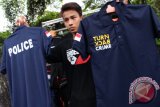 Seorang pedagang memperlihatkan kaos beratribut "Turn Back Crime" dagangannya di Medan, Sumatera Utara, Kamis (26/5). Kaos fenomena yang sedang populer di masyarakat saat ini dijual dengan harga Rp60 ribu. ANTARA SUMUT/Septianda Perdana/16