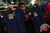 Seorang pedagang memperlihatkan kaos beratribut "Turn Back Crime" dagangannya di Medan, Sumatera Utara, Kamis (26/5). Kaos fenomena yang sedang populer di masyarakat saat ini dijual dengan harga Rp60 ribu. ANTARA SUMUT/Septianda Perdana/16