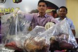 Kanit III/Industri, Pangan, dan Perlindungan Konsumen, Subdit I Ditreskrimsus Polda Jatim, Kompol Roman Smaradhana Elhaj menunjukkan daging sapi (kiri) dan oplosan daging sapi dan babi ketika ungkap kasus di Mapolda Jawa Timur, Kamis (26/5). Ditreskrimsus Polda Jatim berhasil mengamankan barang bukti berupa 16 kilogram oplosan daging sapi dan babi yang diperjual belikan di pasar LMKM Semolowaru, Sukolilo, Surabaya yang telah berlangsung sejak tahun 2015. ANTARA FOTO/M Risyal Hidayat/nz/16