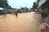Sejumlah warga dan kendaraan berjalan melewati genangan banjir di Jalan D.I Panjaitan, Samarinda, Jumat (27/5). Jalan yang menghubungkan Samarinda-Bontang itu tergenang banjir akibat hujan deras yang mengguyur selama beberapa jam. (ANTARA Kaltim/M Ghofar)