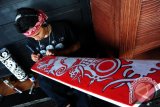 Seorang pria suku Dayak melukis perisai di arena Pekan Gawai Dayak ke-31 di Rumah Radakng, Pontianak, Kalbar, Kamis (26/5). Lomba yang diikuti sejumlah seniman Dayak yang merupakan bagian dari rangkaian Pekan Gawai Dayak ke-31 tersebut, adalah salah satu upaya untuk melestarikan budaya dan tradisi kesenian Dayak. ANTARA FOTO/Jessica Helena Wuysang/16