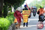 Indra Azwan (tengah), warga Kelurahan Puwantoro, Kecamatan Blimbing, Malang, Jatim, melakukan aksi jalan kaki ketika melintas di Pontianak, Kalbar, Jumat (3/6). Indra Azwan (57) tiba di Kota Pontianak yang menjadi kota ke-17 yang dikunjunginya saat melakukan aksi jalan kaki untuk menjelajahi nusantara, dalam rangka mencari keadilan atas kasus tabrak lari yang dilakukan oknum anggota kepolisian hingga mengakibatkan anaknya tewas pada 1993. Indra mengaku tidak akan berhenti berjalan kaki sampai dipanggil untuk bertemu Presiden Jokowi atau meninggal diperjalanan. ANTARA FOTO/Jessica Helena Wuysang/16
