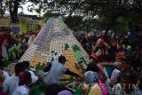 Pengunjung berebut gunungan kue apem di GOR Jombang, Jawa Timur, Minggu (5/6). Tradisi grebek apem yang digelar setiap tahun, tersebut untuk menandai awal Ramadan. Antara Jatim/Syaiful Arif/zk/16