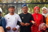 Walikota Bogor Bima Arya bersama Walikota Bandung Ridwan Kamil berpegangan tangan saat kegiatan Memeluk Kebun Raya di jalan Juanda, Kota Bogor, Jawa Barat, Minggu (5/6). Kegiatan memeluk Kebun Raya Bogor yang diikuti 3500 warga dari berbagai elemen dan lapisan masyarakat tersebut untuk menggugah kesadaran dan kecintaan masyarakat untuk menjaga kebersihan dan keindahan kebun raya sebagai warisan pusaka. (ANTARA FOTO/Arif Firmansyah/16).