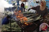 Seorang pedagang membakar batang rotan (Pakat) untuk dijual, di kawasan Jalan Letda Sudjono Medan, Sumatera Utara, Kamis (9/6). Pakat yang merupakan makanan khas Batak Mandailing yang muncul pada bulan Ramadan tersebut dijual dengan harga Rp2.000 perbatangnya sebagai penambah nafsu makan di saat santap sahur dan berbuka puasa. ANTARA SUMUT/Septianda Perdana/16