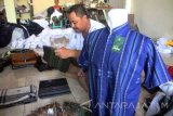 Pekerja menyortir sarung cacat produksi untuk didesain ulang menjadi baju koko atau gamis di sentra industri konveksi rumahan di lingkungan Majan, Tulungagung, Jawa Timur, Jumat (10/6). Menurut pengusaha dan pedagang, permintaan busana muslim selama Ramadan meningkat antara 50-100 persen dibanding hari biasanya dengan pemasaran sejumlah kabupaten/kota di Jatim. Antara Jatim/Destyan Sujarwoko/zk/16