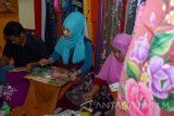 Sejumlah pengrajin melukis dengan media busana kain di industri rumahan Candi, Sidoarjo, Jawa Timur, Sabtu (11/6). Permintaan busana kain lukis pada bulan Ramadan mengalami kenaikan 50 persen dibanding hari biasanya, di jual dengan harga Rp350 ribu hingga Rp2 juta dan dipasarkan ke berbagai daerah di Indonesia terutama Medan. Antara Jatim/Umarul Faruq/zk/16