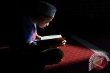 Seorang anak kecil membaca kitab suci Al Quran di Masjid Raya Al Mashun, Medan, Sumatera Utara, Minggu (12/6). Selama bulan suci Ramadan, umat muslim terus berupaya meningkatkan ibadah, dengan cara memperbanyak amalan-amalan yang disunahkan. ANTARA SUMUT/Septianda Perdana/16