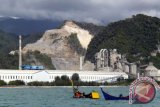 Perahu nelayan berada di peraian pantai dengan latar belakang pabrik semen PT Lafarge Cement Indonesia dan areal penambangan bahan baku semen di Lhoknga, Kabupaten Aceh Besar, Aceh, Sabtu (11/6). Kementerian Perindustrian memperkirakan total kapasitas semen nasional pada 2017 akan mencapai 102 juta ton dari total kebutuhan 70 juta ton per tahun, seiring dengan tingginya realisasi investasi pada industri semen di dalam negeri. ANTARA FOTO/Ampelsa/aww/16.