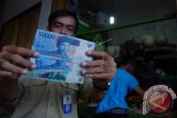 Petugas menunjukan uang palsu pecahan Rp20.000 dan Rp50.000 di Pasar Kepuh, Kuningan, Jawa Barat, Senin (13/6). Sejak awal Ramadan, petugas mengamankan uang palsu sebanyak Rp220.000 yang di dapatkan dari sejumlah pedagang saat bertransaksi oleh pembeli di pasar setempat. ANTARA FOTO/Ivan Pramana Putra/wdy/16.