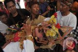 Sejumlah warga berupaya menenangkan penari yang kesurupan seusai pagelaran tari sakral Bali pada Pesta Kesenian Bali ke-38 di Taman Budaya Denpasar, Rabu (15/6). Sedikitnya 9 penari kesurupan setelah mementaskan Tari Legong dan Tari Barong. ANTARA FOTO/Nyoman Budhiana/i018/2016.