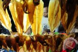 Seorang pedagang menyiapkan Sopang atau Sotong Pangkong yang dijual seharga Rp10 ribu - Rp40 ribu per potong, di Jalan Merdeka Barat, Pontianak, Kalbar, Selasa (14/6) malam. Sopang adalah kuliner khas Pontianak berupa cumi-cumi kering bakar yang dipukul-pukul dengan menggunakan palu, dan dijual hanya pada malam hari selama bulan Ramadan. ANTARA FOTO/Jessica Helena Wuysang/16