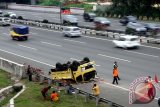 Petugas mengevakuasi truk yang terguling di Tol Jorr Gerbang Tol Dukuh, Jakarta Timur, Selasa (14/6/2016). Kecelakaan tunggal yang disebabkan pecahnya salah satu ban tersebut tidak mengakibatkan korban jiwa, melainkan tiga orang awak truk terluka. (Foto Yulius Satria Wijaya)