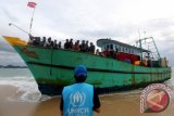 Petugas United Nations High Commissioner for Refugees (UNHCR) berkomunikasi dengan para imigran asal Sri lanka yang masih berada diatas kapal di Pantai Pulo Kapuk, Lhoknga, Aceh Besar, Aceh, Selasa (14/6). Sebanyak 44 imigran yang terdiri dari sembilan anak-anak, 15 perempuan dan 20 laki-laki masih bertahan di atas kapal karena tidak diizinkan turun kedaratan hingga ada keputusan dari Pemeritah. ANTARA FOTO/Irwansyah Putra/pd/16.