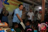 Menteri Koordinator Maritim dan Sumber Daya, Rizal Ramli (kedua kiri) didampingi Gubernur Sumatera Utara T Erry Nuradi (ketiga kiri) meminta seorang anak membaca buku ketika mengunjungi Perpustakaan Terapung Kampung Nelayan Belawan, di Medan, Sumatera Utara, Jumat (17/6). Kunjungan Menko Maritim dan Sumber Daya ke lokasi tersebut, dalam rangka memberikan bantuan fasilitas perpustakaan. ANTARA FOTO/Irsan Mulyadi/wdy/16.