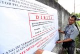 Jurusita pajak memasang tanda penyitaan aset di salah satu bangunan dan tanah di Kecamatan Ponggok Blitar, Jawa Timur, Kamis (16/5). Kantor Pelayanan Pajak Pratama setempat menyita sejumlah aset berupa tanah dan bangunan milik seorang wajib pajak yang menunggak pembayaran pajak sebesar Rp. 3,6 Miliyar. Antara Jatim/Irfan Anshori/zk/16